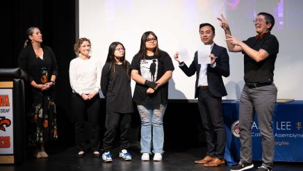 Asm. Lee with students and interpreters on stage